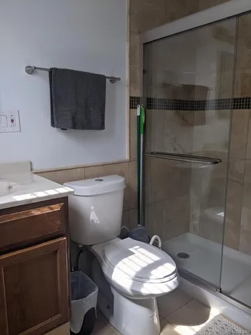a bathroom with a granite countertop sink toilet and mirror