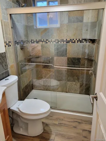 a bathroom with a toilet and a shower