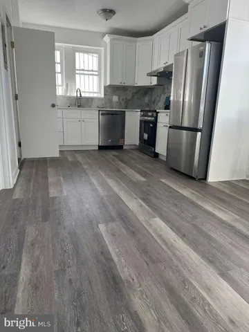 a kitchen with granite countertop a refrigerator stove and sink