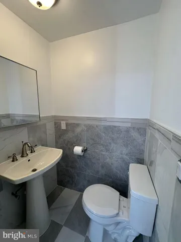 a bathroom with a sink mirror and toilet