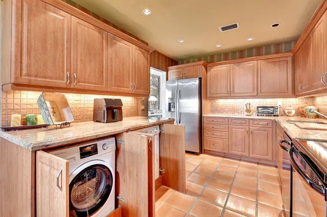 a large kitchen with stainless steel appliances a stove a sink and a dining table view