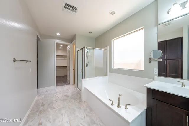 a spacious bathroom with a tub shower sink and mirror