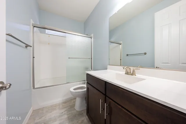 a view of an empty room with closet and a window