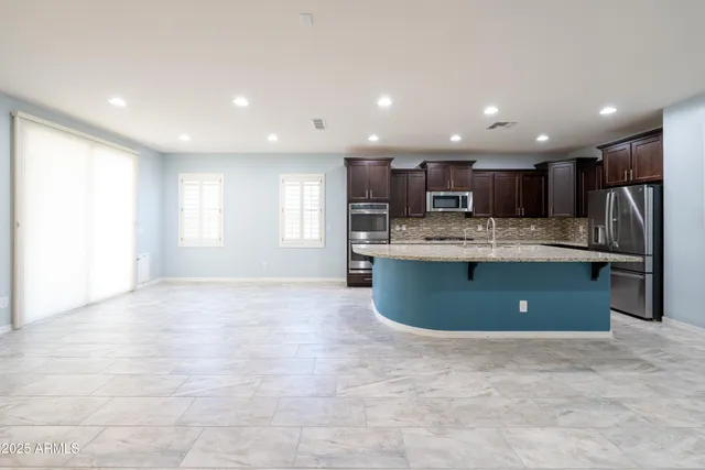a kitchen with stainless steel appliances granite countertop a sink refrigerator and a window