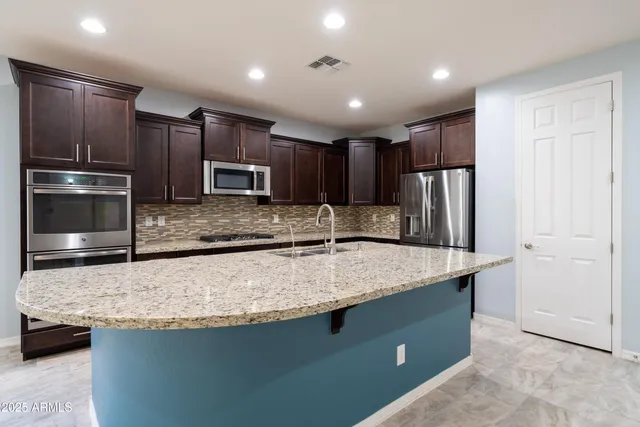 a kitchen with stainless steel appliances granite countertop granite counter tops refrigerator and a stove