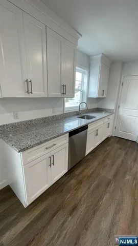 a large kitchen with granite countertop a sink and dishwasher stove top oven