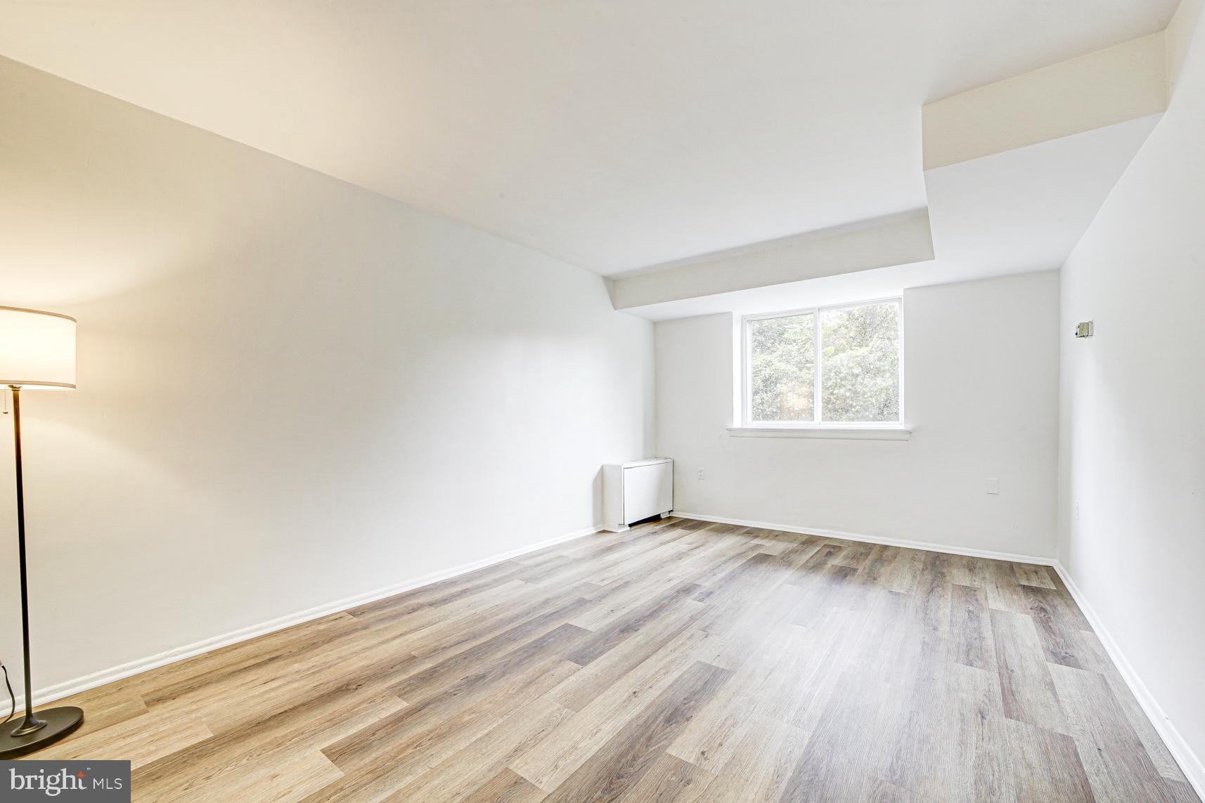 9250 Edwards Way, Unit 207A Hyattsville, MD 20783 - Photo 12 of 17 an empty room with wooden floor and windows