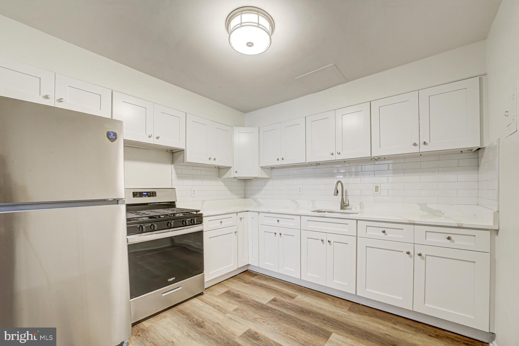 9250 Edwards Way, Unit 207A Hyattsville, MD 20783 - Photo 4 of 17 a kitchen with granite countertop white cabinets and white appliances