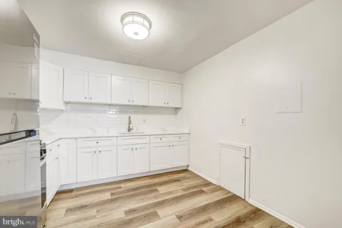 a kitchen with granite countertop white cabinets and white appliances