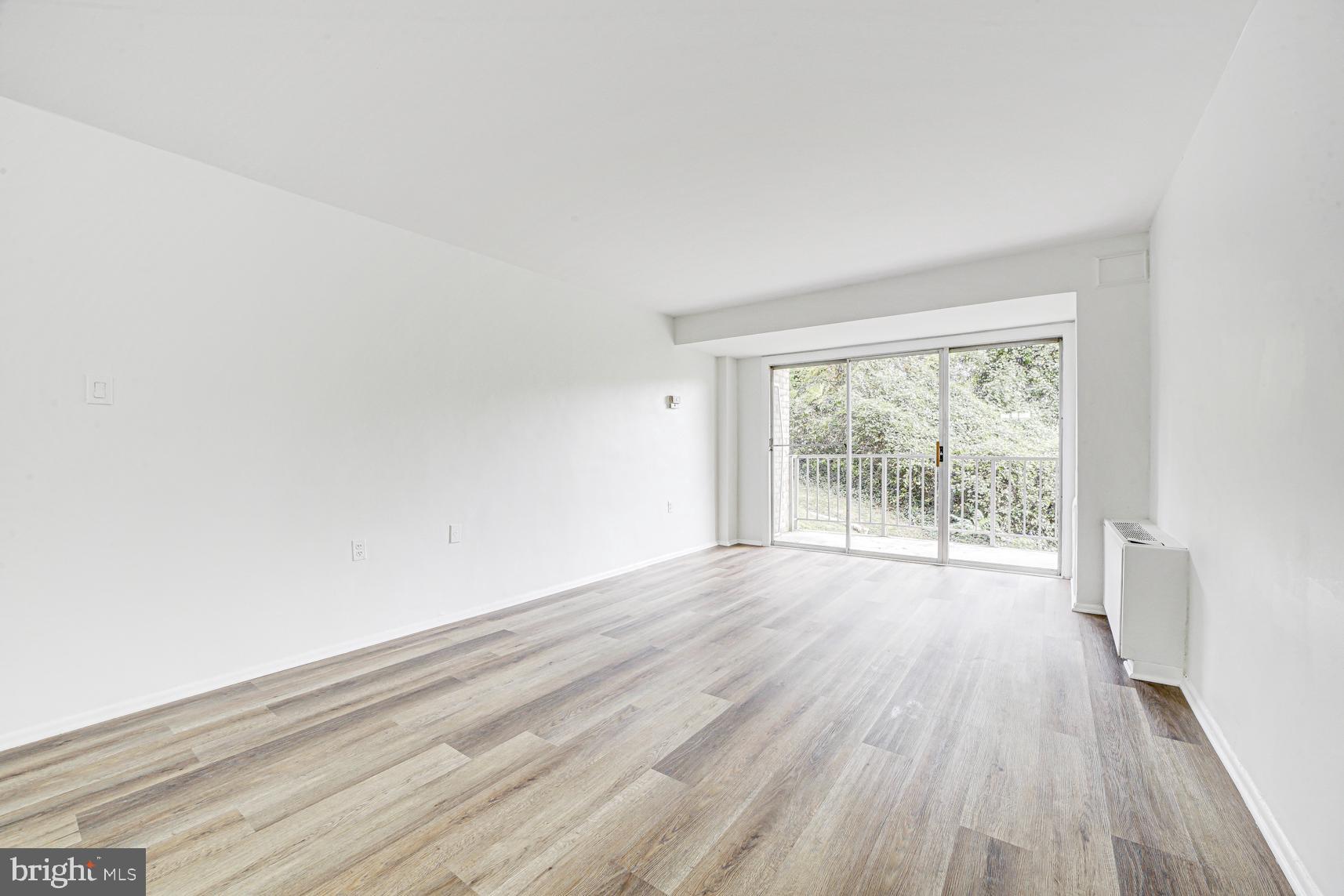 9250 Edwards Way, Unit 207A Hyattsville, MD 20783 - Photo 10 of 17 wooden floor in an empty room with a window