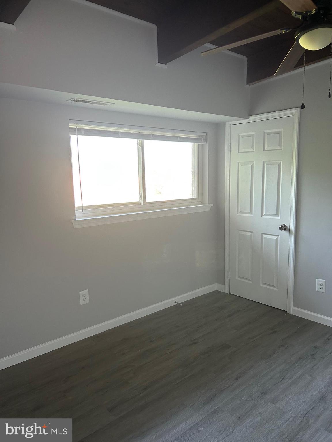 7701 Arehart Drive, Unit 1314 New Carrollton, MD 20784 - Photo 12 of 13 a view of an empty room with wooden floor and a window