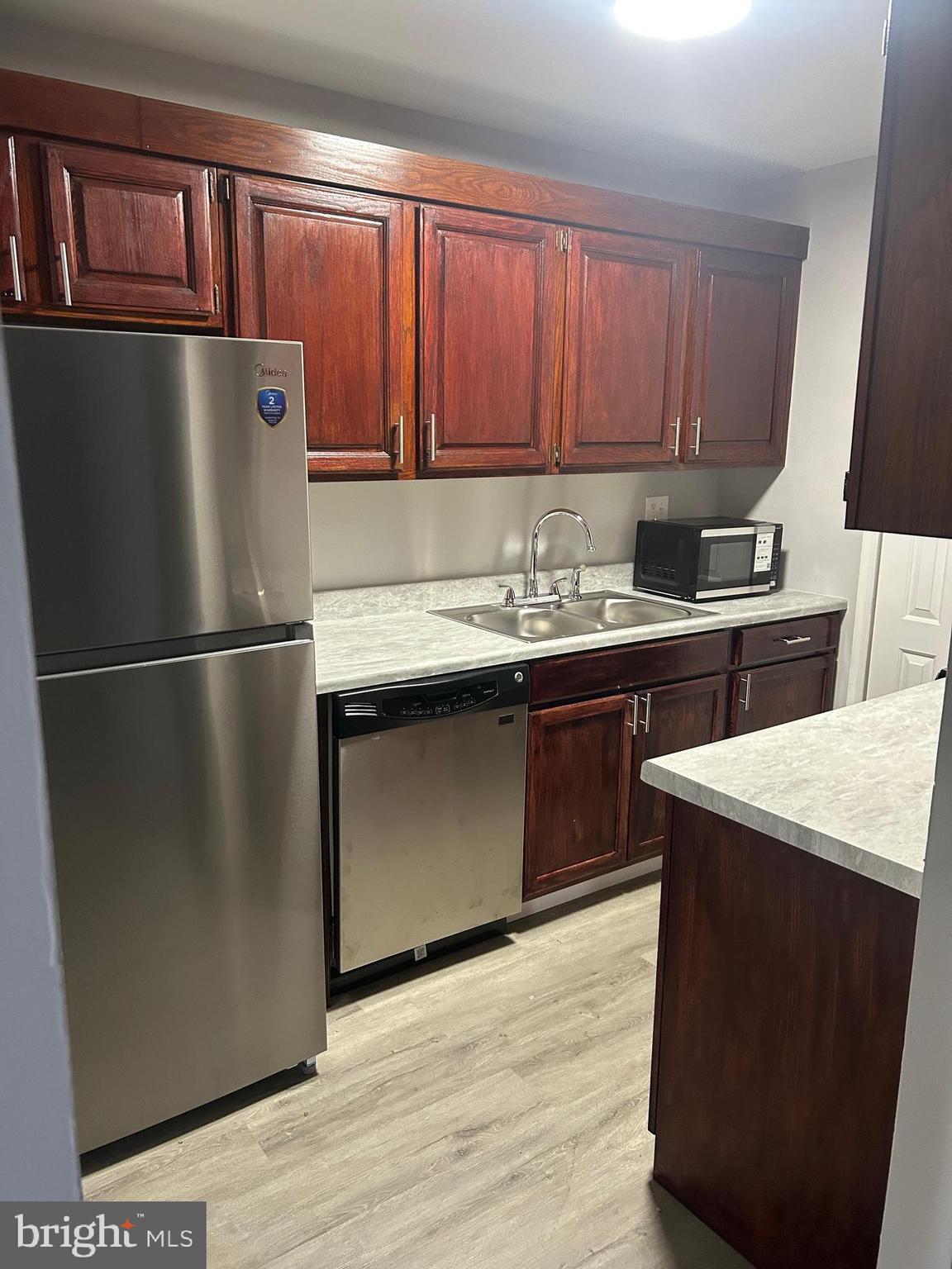 7701 Arehart Drive, Unit 1314 New Carrollton, MD 20784 - Photo 7 of 13 a kitchen with a refrigerator sink and cabinets