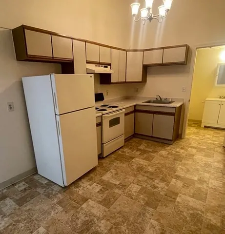 a kitchen with a refrigerator and a stove