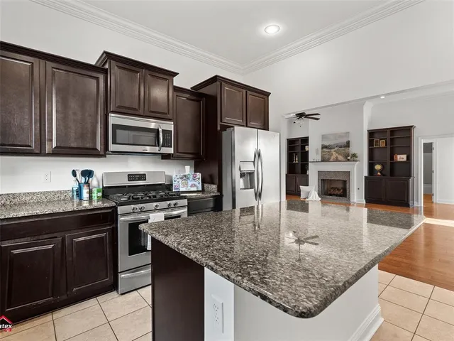 a kitchen with stainless steel appliances granite countertop a stove refrigerator and microwave