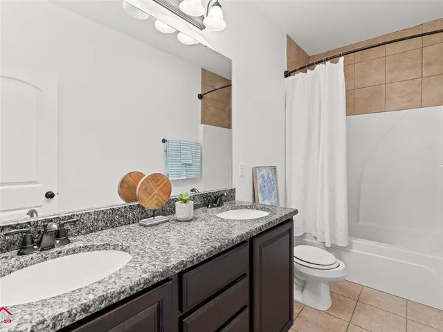 a bathroom with a granite countertop sink toilet a large mirror and shower