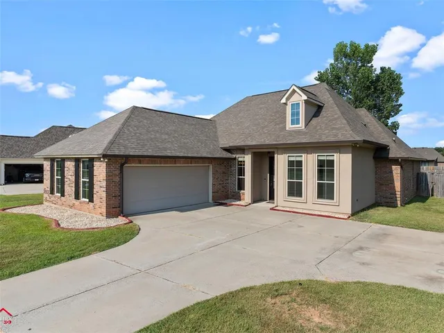 a front view of a house with a garden and yard