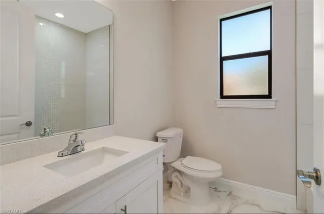 a bathroom with a toilet a sink and mirror