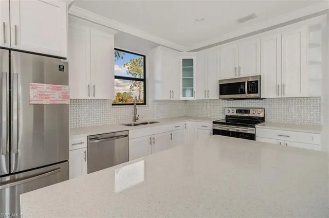 a kitchen with stainless steel appliances a refrigerator sink and microwave