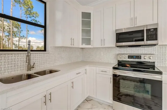 a kitchen with granite countertop a refrigerator stove and sink