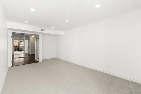 an empty room with kitchen view and sink