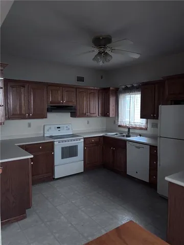 a kitchen with a stove sink and cabinets