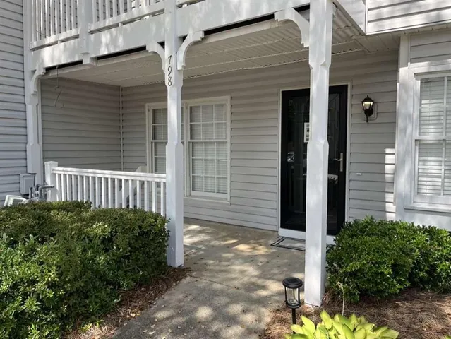 a view of a house with a small yard and wooden floor and fence