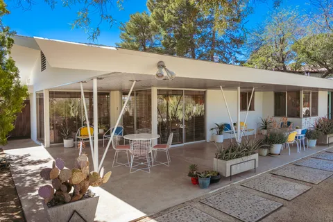a view of a patio with table and chairs with wooden fence and plants