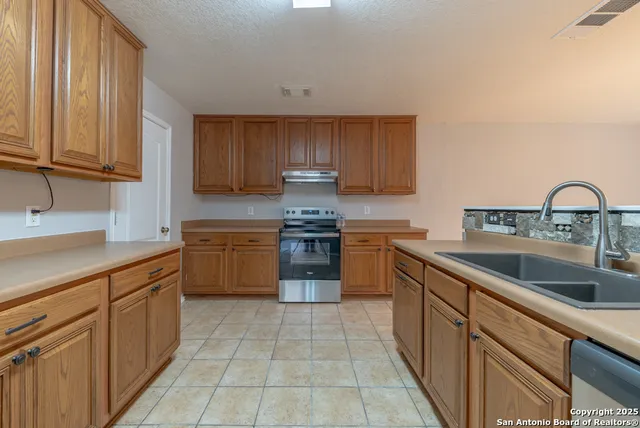 a kitchen with a sink stove and cabinets
