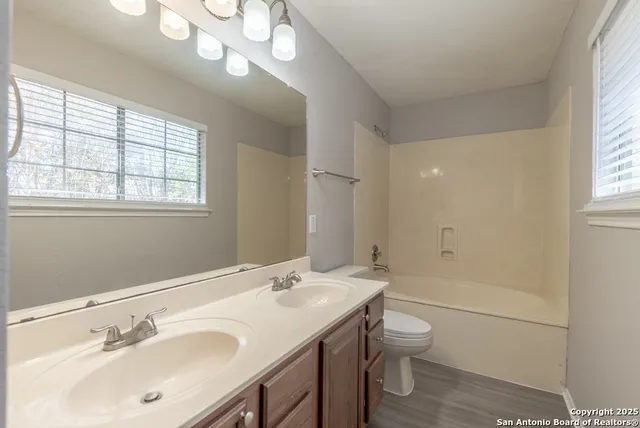 a bathroom with a granite countertop sink a toilet and shower