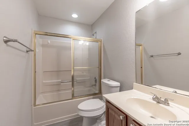 a bathroom with a sink toilet vanity and shower