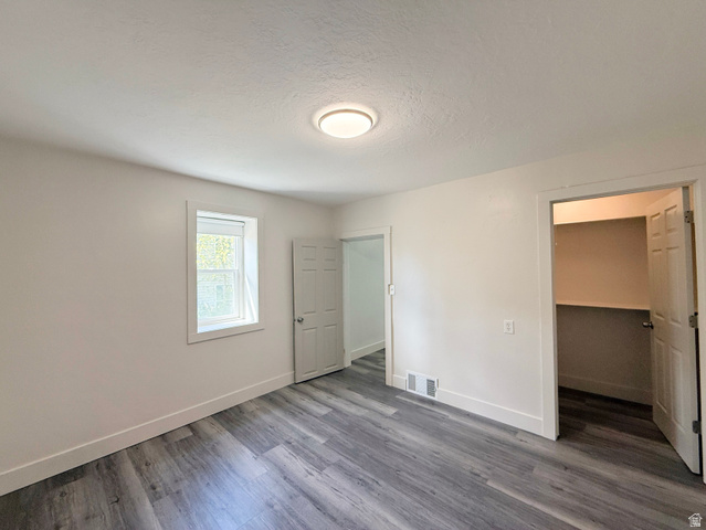 548 27th Street Ogden, UT 84403 - Photo 12 of 13 Unfurnished bedroom with a walk in closet, a textured ceiling, and dark wood-type flooring