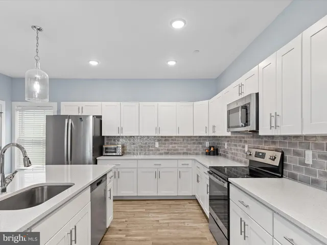 a kitchen with stainless steel appliances a sink stove and refrigerator
