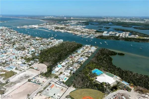 an aerial view of ocean and residential houses with outdoor space