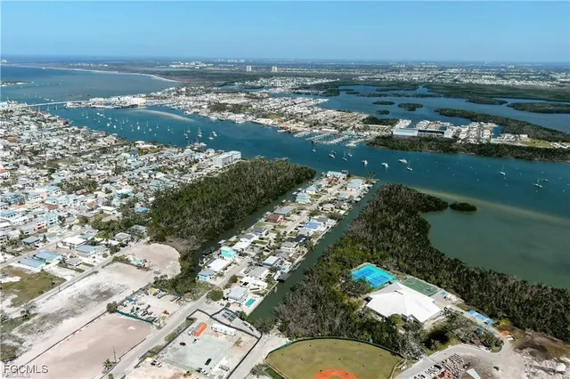 an aerial view of ocean and residential houses with outdoor space