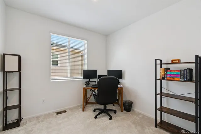 a view of a workspace with furniture and a window