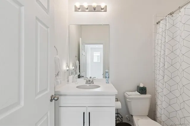 a bathroom with a sink mirror and toilet