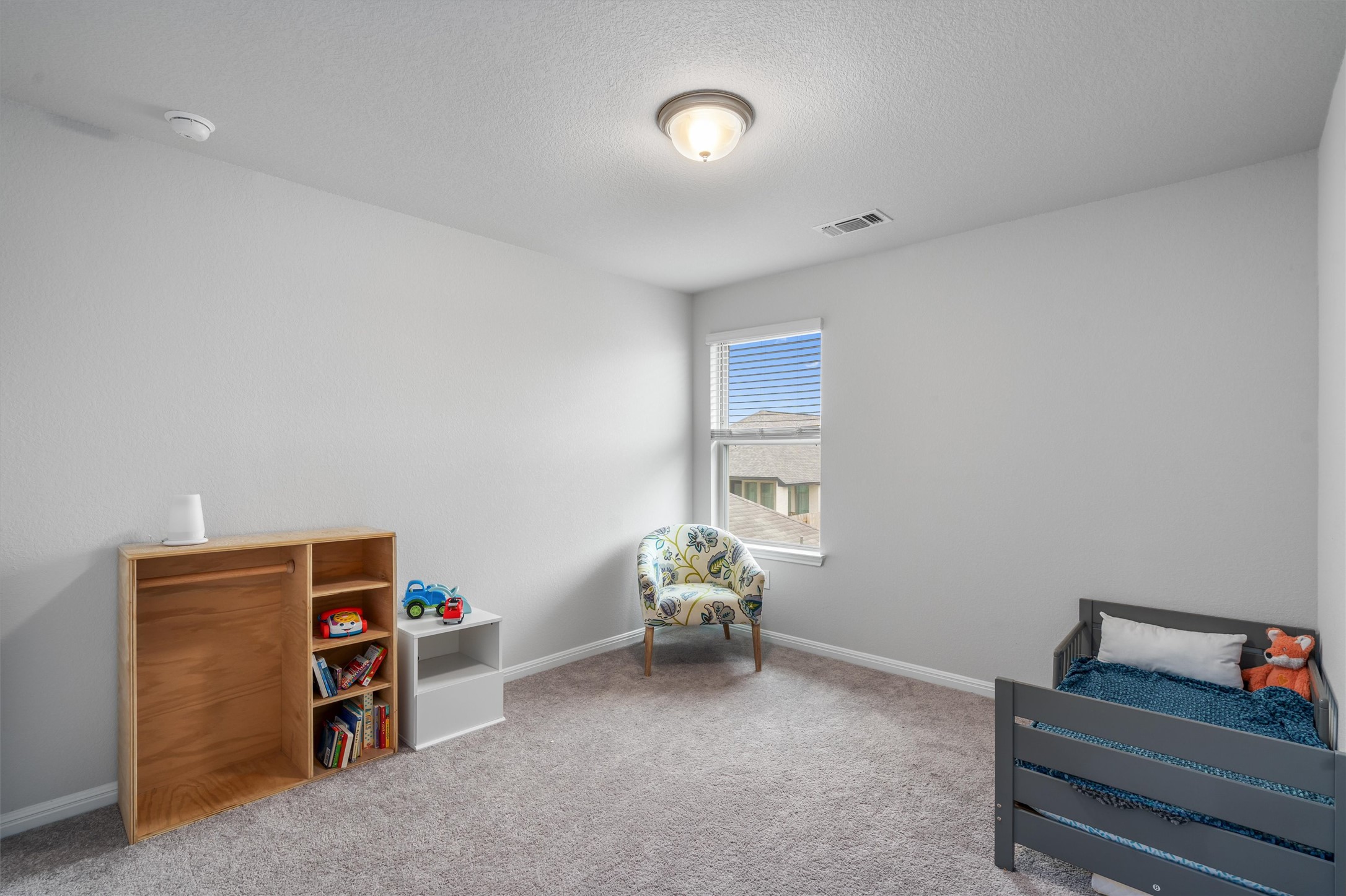 224 Backstays Loop Kyle, TX 78640 - Photo 16 of 19 Carpeted room with a single window featuring blinds, a flush-mount ceiling light fixture, light gray wall paint, and white baseboards