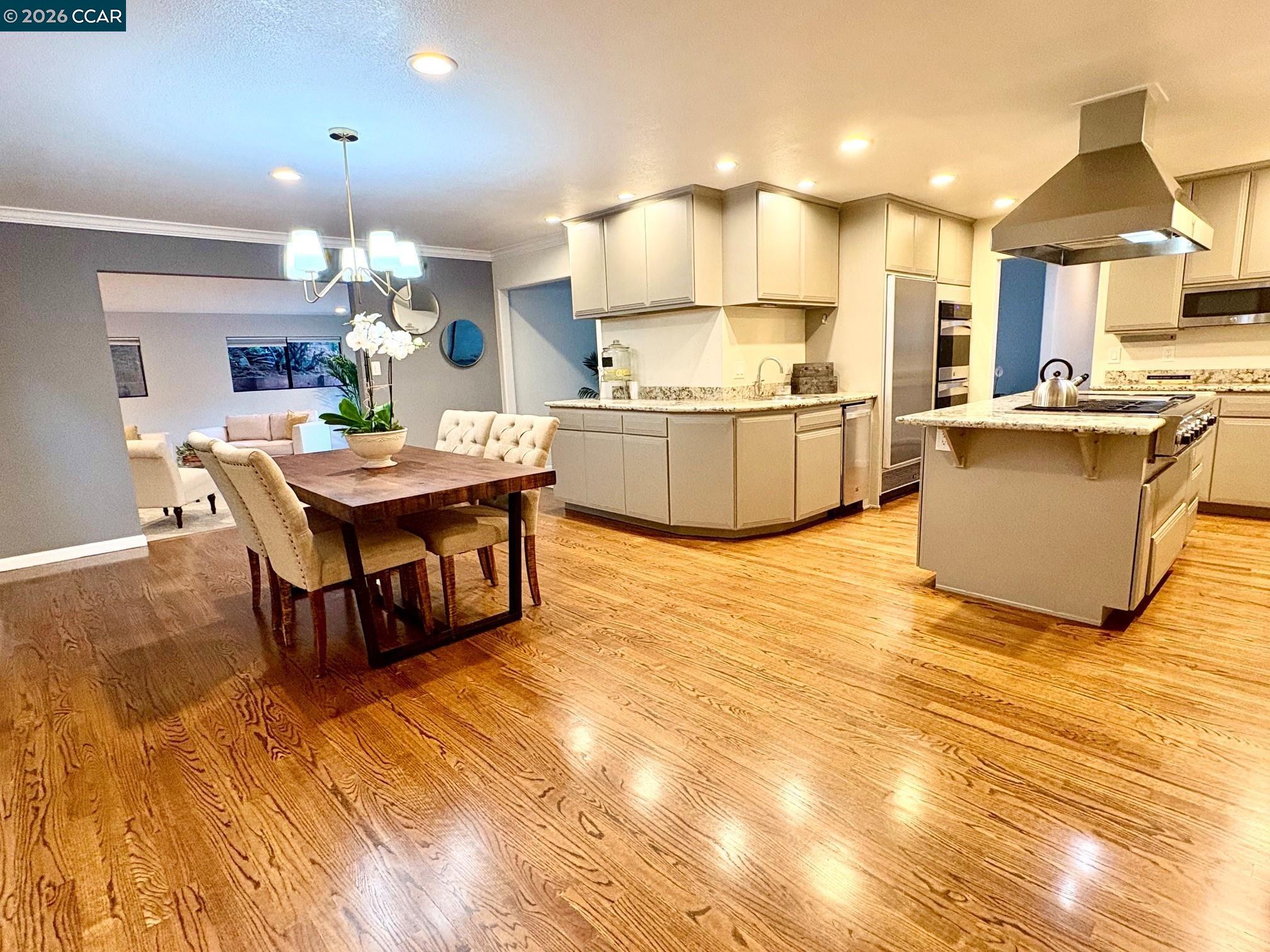 2589 Pebble Beach Loop Lafayette, CA 94549 - Photo 10 of 32 a kitchen with granite countertop a table chairs a sink dishwasher stove and cabinets with wooden floor