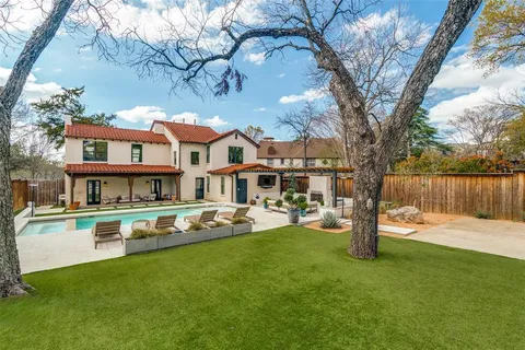 a view of a house with a yard patio and tree