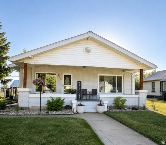 303 North Main Street Grace, ID 83241 - Photo 2 of 22 Front facade featuring a covered porch, white brick siding, horizontal vinyl siding, wood support beams, and a concrete walkway