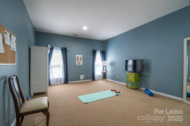 a bedroom with a bed a window and television