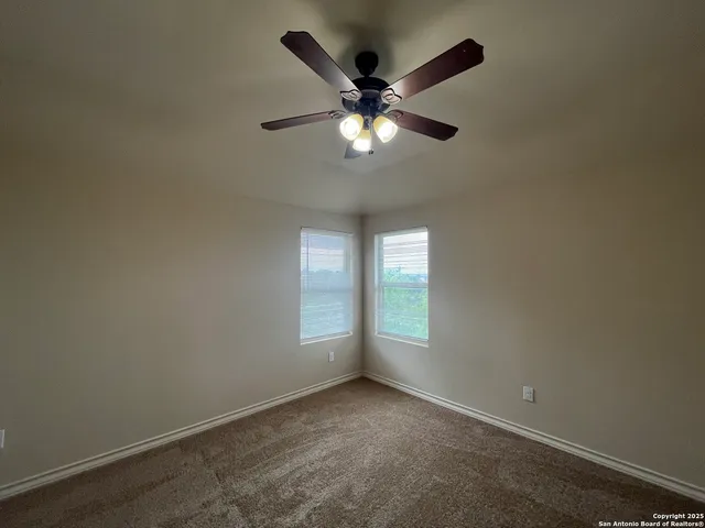 an empty room with a window and a fan