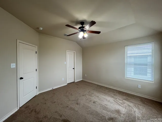 a view of a room with a ceiling fan and a window
