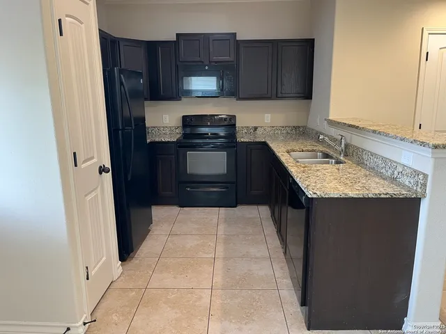 a kitchen with a sink refrigerator and cabinets
