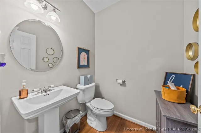 a bathroom with a toilet sink vanity and mirror