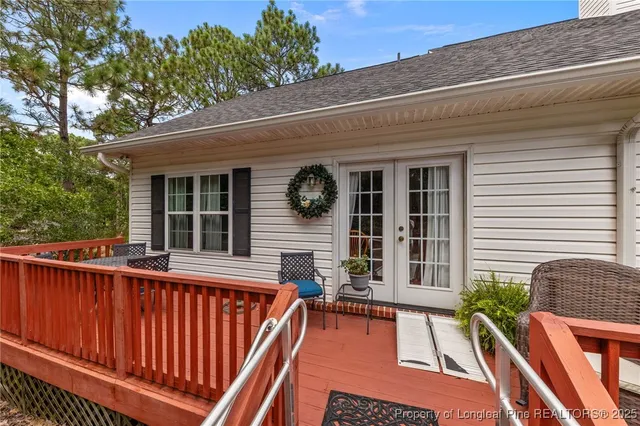 a view of a white house with a yard and potted plants