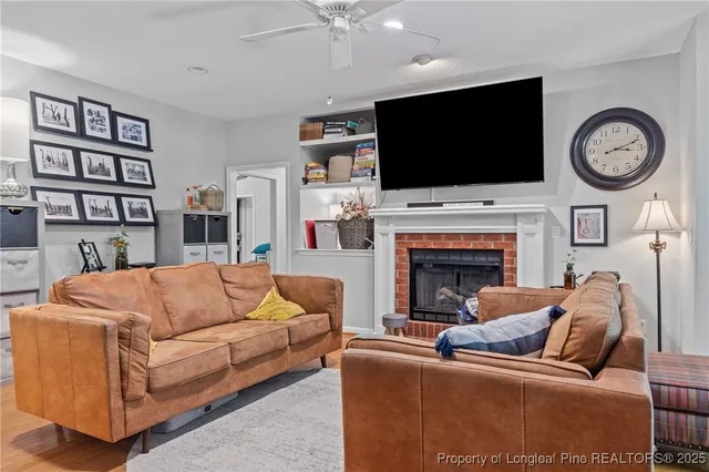 a living room with furniture a flat screen tv and a fireplace