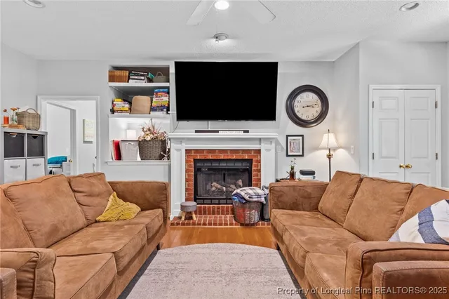 a living room with furniture a flat screen tv and a fireplace