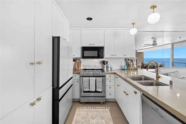 a dining room with stainless steel appliances kitchen island granite countertop a table chairs and a refrigerator