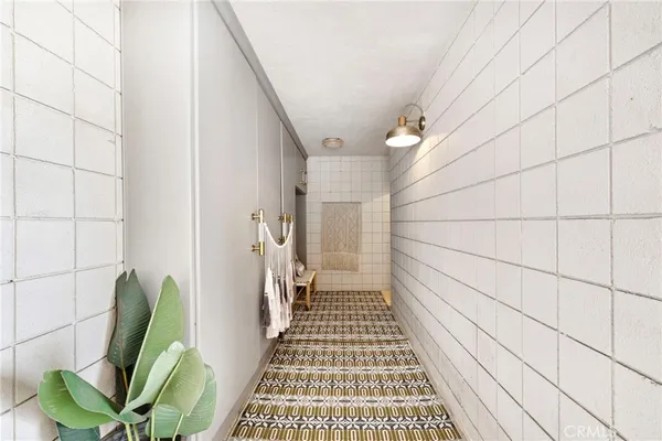 a view of a hallway with wooden floor and a chandelier